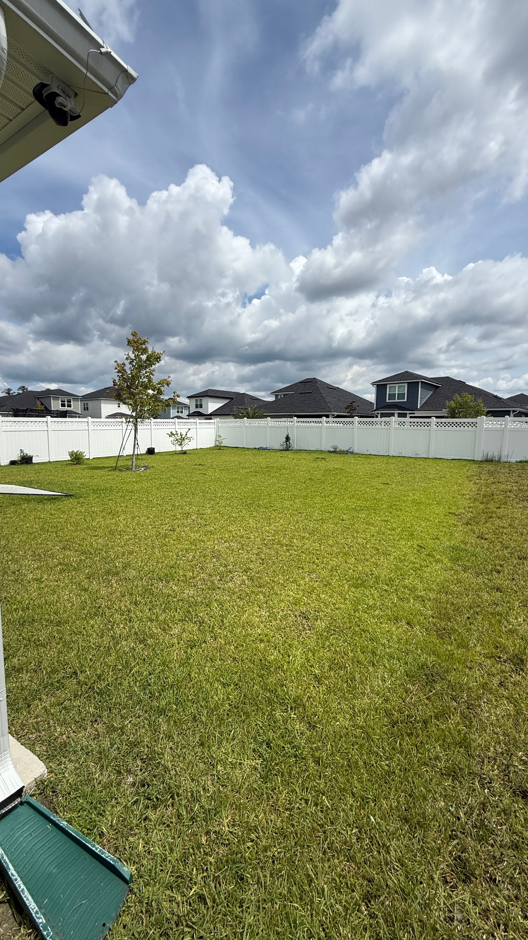 Freshly mowed backyard with white vinyl fence