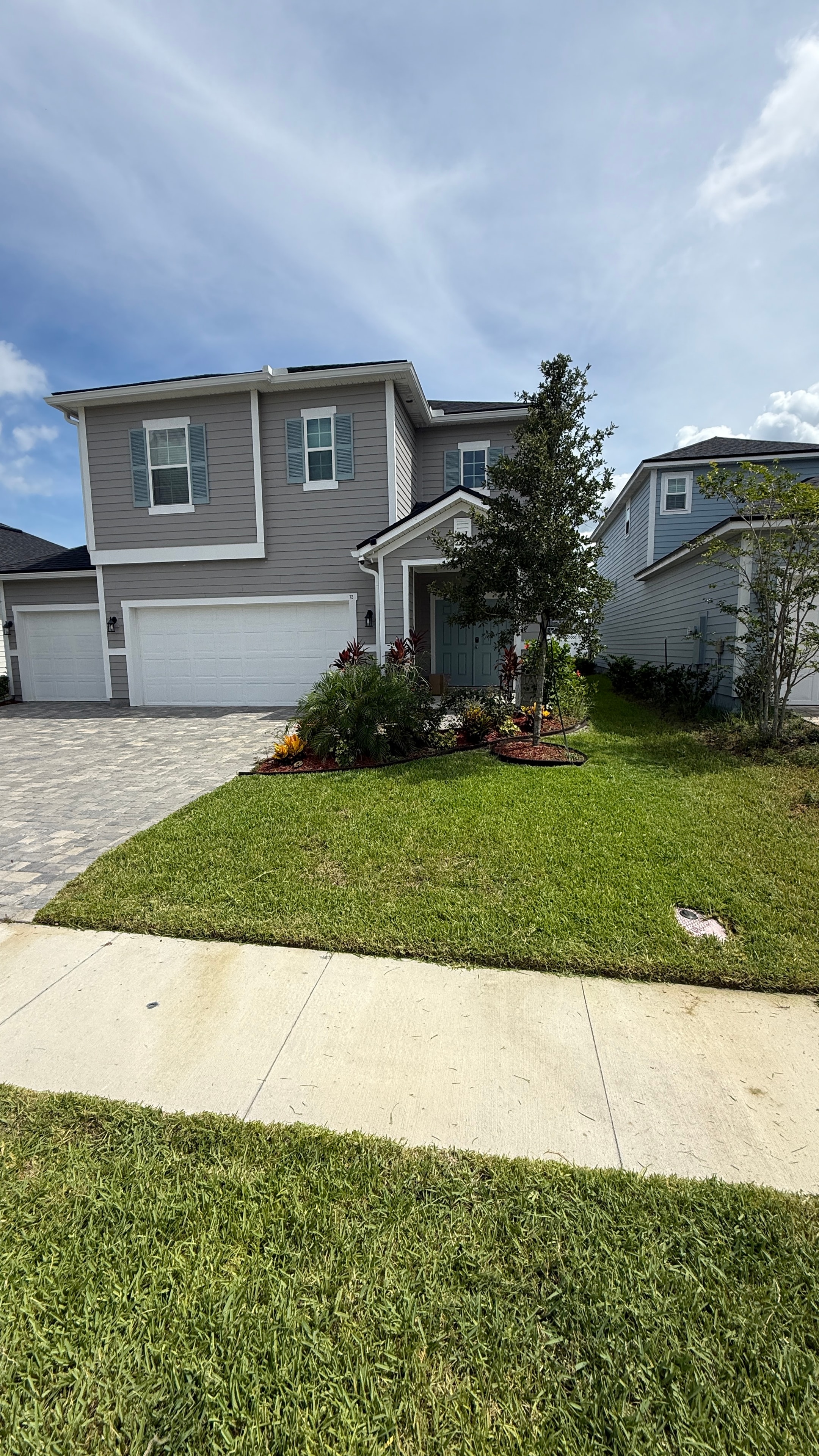 Gray home with colorful flower bed landscaping